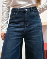 Jean de tiro alto con corte wide leg, confeccionado en denim azul oscuro con costuras en contraste.