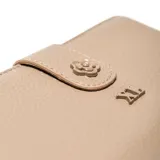 Billetera de símil cuero color taupe, con cierre superior y solapa frontal con broche a presión decorado con una flor en relieve y el logo de la marca.