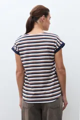 Remera de algodón con estampado de rayas horizontales en tonos azul marino, marrón y blanco. Presenta cuello redondo, mangas cortas con dobladillo y detalle de botones en el lateral inferior.