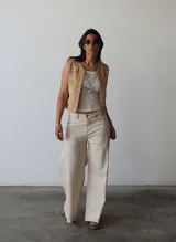 Pantalón de jean color natural, de corte ancho con costuras a la vista y terminación desflecada.