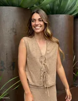 Chaleco blanco tejido en lino con escote en V y cierre frontal con lazos.