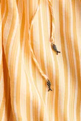 Vestido largo de corte holgado en tejido liviano, con diseño evasé, escote en V y breteles finos para atar en los hombros.