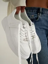 Championes blancos de estilo urbano, con suela de plataforma y cordones.