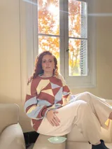 Sweater de punto con diseño geométrico en tonos celeste, marrón y beige.