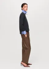 Pantalón efecto piel de color marrón, con diseño recto, tiro medio y cintura elástica con cordón ajustable. Cuenta con dos bolsillos laterales.