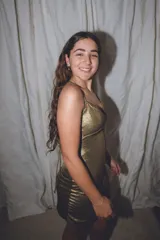 Vestido corto de color verde esmeralda, con escote en pico y breteles finos. Presenta aberturas en los laterales de la cintura y espalda descubierta.