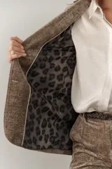 Blazer marrón de terciopelo con solapas de muesca, cierre frontal con un botón, bolsillos delanteros y forro con estampado animal print.