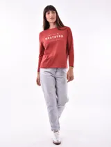 Remera de manga larga color beige, con cuello redondo y estampado frontal que dice "Magic is something you make" en color lila.