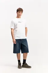 Bermuda de jean estilo baggy, color azul oscuro, con silueta amplia y largo por debajo de la rodilla, confeccionada en 100% algodón.