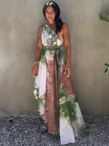 Vestido largo verde con diseño estampado tipo tie-dye y detalles dorados, de corte fluido, un solo hombro y diseño amplio.