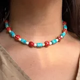 Gargantilla corta con cuentas de colores rojo, turquesa y blanco.