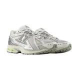 Championes New Balance modelo 1906R, de diseño técnico y deportivo en tonos gris, blanco y plateado, con detalles en verde lima. Presenta una estructura de malla transpirable con refuerzos sintéticos y entresuela amortiguada.