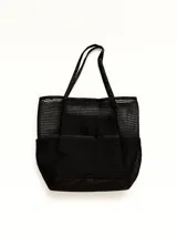 Bolso tipo tote bag de malla negra, con base y bolsillos exteriores de tela lisa negra. Posee dos asas de hombro y un diseño de red.