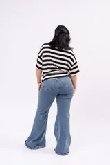 Pantalón jean estilo oxford de tiro alto, color azul intermedio, con calce ajustado en cadera y muslos, y bota ancha acampanada.