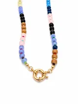 Collar de cuentas de vidrio multicolor con cierre frontal de mosquetón circular en tono dorado.