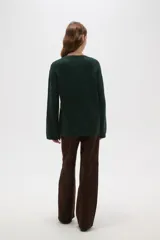 Sweater de punto jacquard con diseño floral abstracto en tonos tierra sobre fondo negro, de corte holgado, cuello redondo y manga larga.