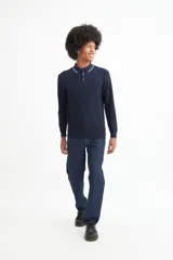 Sweater de punto color beige con cuello polo blanco y mangas largas.