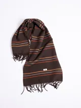 Bufanda de tejido suave en color marrón chocolate con diseño de rayas horizontales en tonos naranja, beige y gris. Presenta terminaciones con flecos en los extremos.