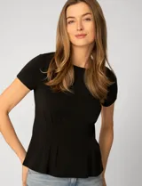 Remera de manga corta color negro, confeccionada en mezcla de modal. Presenta un diseño con alforzas verticales en el frente que aportan estructura y una silueta ligeramente acampanada.