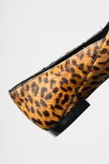 Zapato plano tipo ballerina con escote en V y punta cuadrada, confeccionado en cuero con estampado animal print de leopardo.