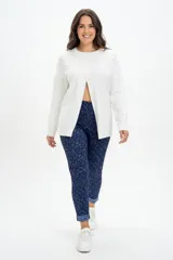 Pantalón de corte ajustado confeccionado en tejido jacquard con estampado sutil en tonos azules. Presenta bolsillos delanteros funcionales, cierre frontal y un diseño que estiliza la figura.