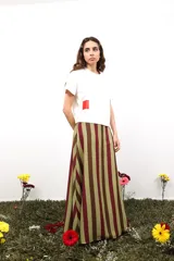 Falda larga de gasa con estampado tipográfico en color bordó sobre fondo beige. Presenta una silueta fluida y cierre lateral oculto.