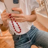 Llavero para celular con cuentas cúbicas de color rojo y cuentas plateadas.