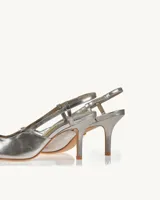 Zapato de tacón plateado con punta fina y aplique de strass.