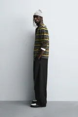 Pantalón de corte balloon fit en color gris, confeccionado en tejido con viscosa. Presenta pliegues frontales, cintura con cinturón integrado a contraste, bolsillos laterales y bolsillos traseros de vivo.