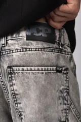 Bermuda de jean de corte mom, estilo carpintero, con lavado ácido gris claro. Presenta costuras marcadas, bolsillos funcionales y detalles de refuerzo en los laterales.