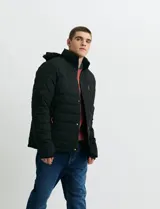 Campera puffer verde militar de cuello alto, con cierre frontal y solapa con broches a presión. Cuenta con bolsillos laterales y un bolsillo vertical en el pecho con cierre, ambos con tiradores naranjas.
