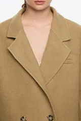 Chaquetón de corte recto confeccionado en mezcla de lana doble faz, con doble botonadura frontal, cuello con solapa, manga larga y bolsillos de tapeta.