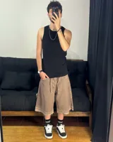 Bermuda de corte baggy color marrón con efecto gastado (lavado vintage), doble carpintero y detalle artesanal visible en el bajo. Incluye un cordón extra confeccionado en la misma tela.