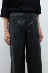 Pantalón de tiro alto confeccionado en eco cuero negro, con diseño de pierna ancha y pinzas frontales.