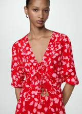 Blusa roja con estampado de flores rosas, escote en V con lazos y mangas 3/4.