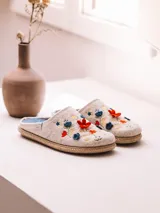 Pantuflas para mujer color beige melange con diseño bordado de flores coloridas en el empeine y suela revestida en yute trenzado.
