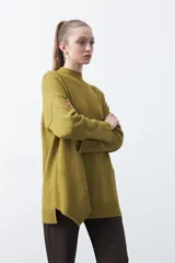 Polera de tejido de punto color marrón, con diseño asimétrico y costura diagonal frontal. Presenta cuello alto, hombros caídos, mangas largas con puños acanalados y ruedo con abertura frontal.