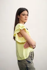 Remera color amarillo pastel con cuello redondo y mangas cortas con volados.