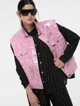 Chaleco denim rosa con efecto metalizado plateado, sin mangas y con cierre de botones.