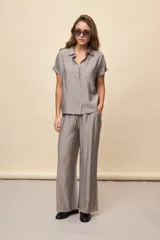 Pantalón gris de corte amplio y silueta fluida, con cintura elástica y cordón ajustable.