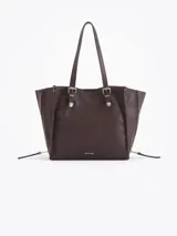 Cartera tote de cuero vacuno color marrón, con doble asa de hombro, detalles metálicos plateados y cierres laterales decorativos.