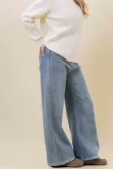 Jean wide leg de tiro alto con calce relajado y pierna amplia. Confeccionado en denim con leve desgaste, cuenta con cintura definida con presillas, bolsillos clásicos y cierre frontal con botón metálico.