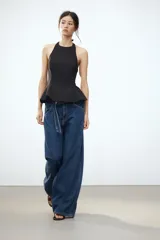 Top rosa claro, entallado, con cuello halter que se abrocha en la nuca y espalda descubierta. El bajo tiene un corte peplum acampanado.