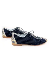 Zapato tipo blucher de terciopelo de seda azul marino con diseño rayado. Presenta una abertura central ajustable con cordones, ribetes en contraste y detalles en piel con estampado de pitón multicolor en la puntera y el talón. Cuenta con suela de cuero.