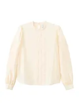 Blusa color crudo con cuello alto, detalles de bordados verticales en el frente y mangas largas abullonadas con puños ajustados.