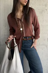 Camisa de tejido liviano y calce relajado, color marrón chocolate, con cuello mao, mangas largas y detalle de puntilla y bordado en contraste a lo largo de la botonadura frontal.