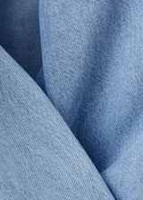 Top halter de denim suave color celeste, con escote en V cruzado y diseño corto.