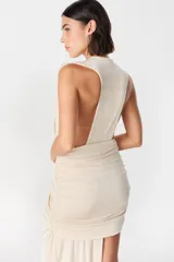 Vestido corto de diseño asimétrico en color verde oliva, con escote profundo en V, drapeado frontal y una caída lateral larga que llega hasta el suelo. Sin mangas y con ajuste entallado en la falda.