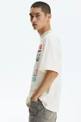 Remera de algodón color beige con diseño estampado de la banda Red Hot Chili Peppers, de corte oversized y mangas cortas.