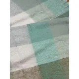 Bufanda rectangular de tejido grueso con diseño de cuadros en tonos azul, naranja, gris y beige, terminada con flecos en los extremos.